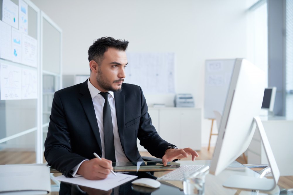 busy-caucasian-man-suit-sitting-office-working-computer.jpg